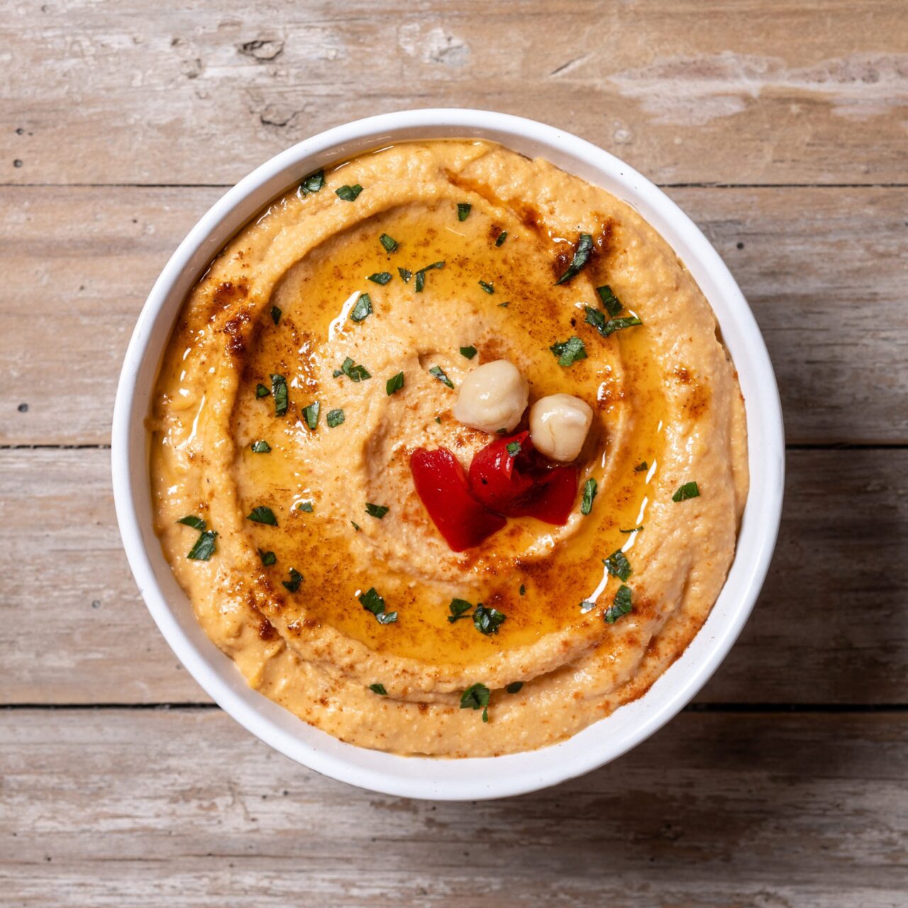 Roasted red pepper hummus on wooden table Smoky Pepper Hummus
